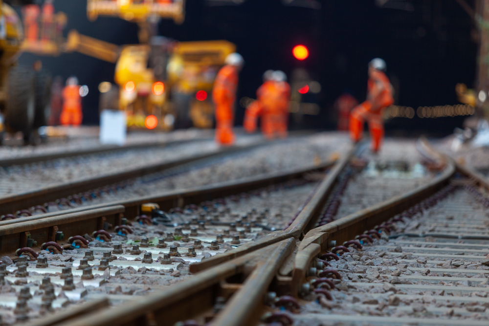 A group of construction workers on a train track.